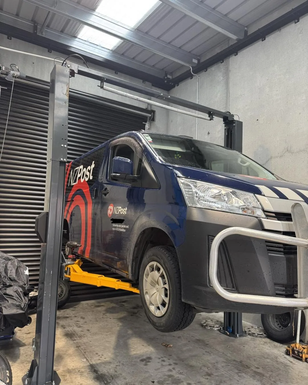 A fleet van up on the hoist in the Mobile Automotive Solutions workshop